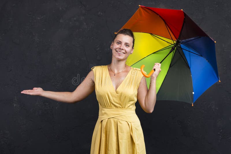 Retrato do estúdio da jovem mulher em um vestido com um guarda-chuva em sua mão Previsão de tempo imagem de stock Retrato do estúdio da jovem mulher em um vestido com um guarda-chuva em sua mão Previsão de tempo imagem de stock
