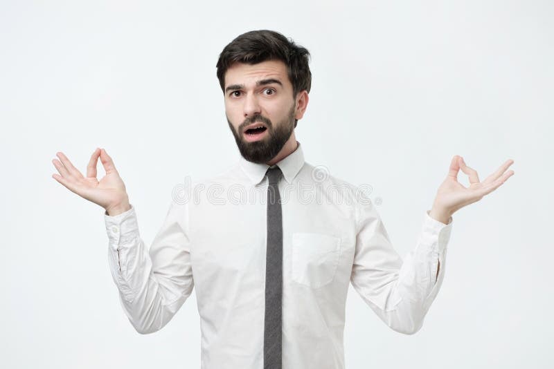 Retrato do estúdio do homem considerável novo na camisa branca, na pose da meditação, tentando relaxar imagem de stock Retrato do estúdio do homem considerável novo na camisa branca, na pose da meditação, tentando relaxar imagem de stock