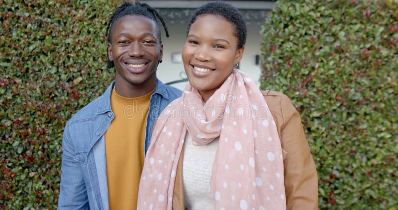 Retrato do feliz casal africano-americano em movimento lento, do lado de fora da casa