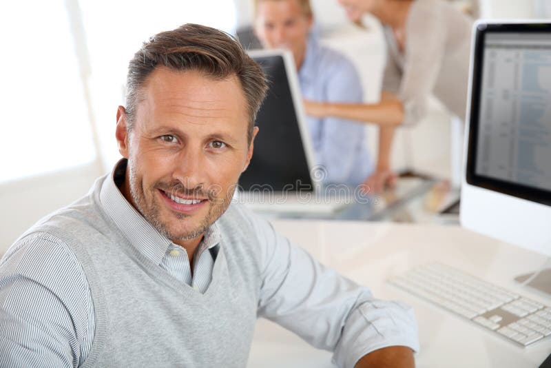 Retrato do homem de meia idade que trabalha com computador fotografia de stock Retrato do homem de meia idade que trabalha com computador fotografia de stock