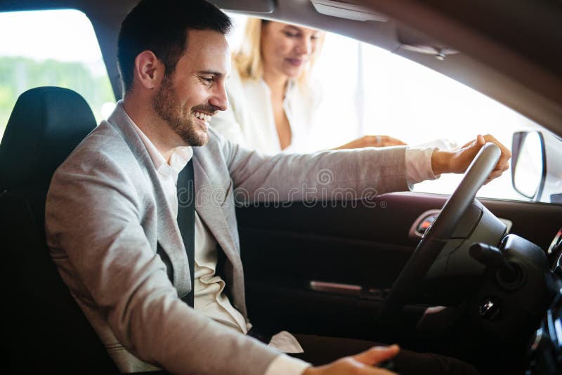 Retrato do homem novo considerável que toma o carro luxuoso para a movimentação, o assento interno e o sorriso do teste foto de stock Retrato do homem novo considerável que toma o carro luxuoso para a movimentação, o assento interno e o sorriso do teste foto de stock