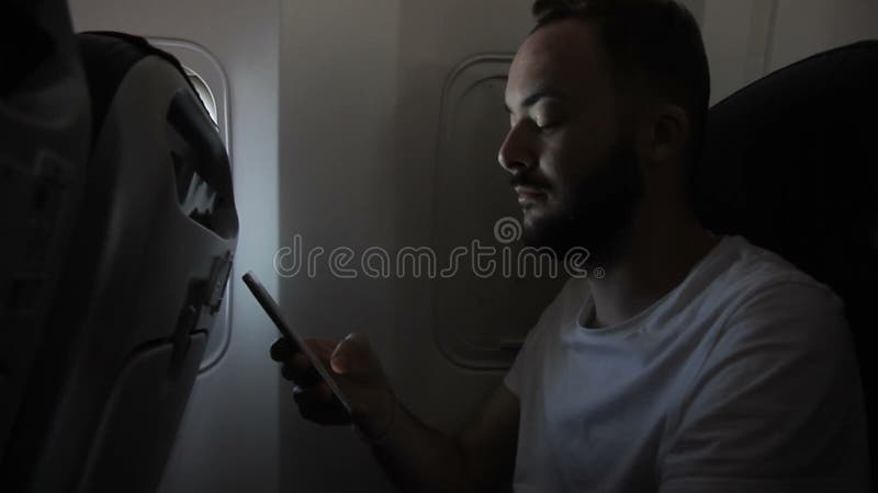 Retrato do homem novo, que está usando seu smartphone nos aviões