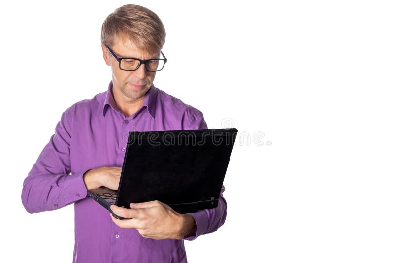 Retrato do indivíduo considerável na camisa e em vidros ocasionais usando o laptop Funcionamento do homem ocupado foto de stock Retrato do indivíduo considerável na camisa e em vidros ocasionais usando o laptop Funcionamento do homem ocupado foto de stock