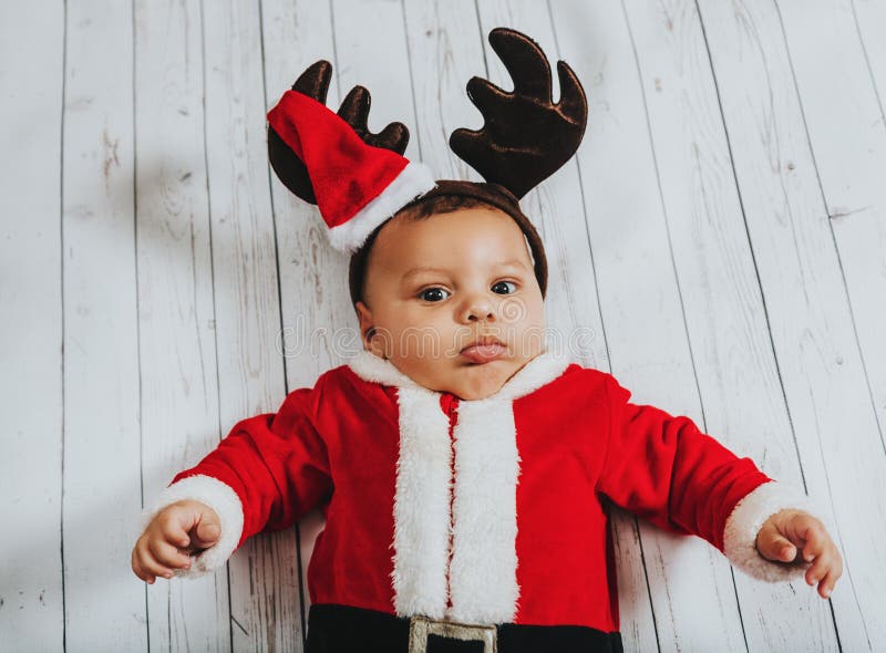 Retrato do Natal do bebê recém-nascido adorável que veste o equipamento do ` de Santa Claus imagens de stock royalty free Retrato do Natal do bebê recém-nascido adorável que veste o equipamento do ` de Santa Claus imagens de stock royalty free