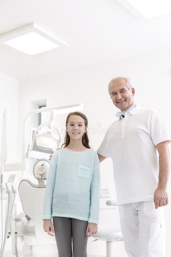 Retrato do paciente do dentista e da menina na clínica dental