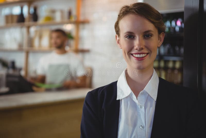 Retrato do proprietário feliz com o garçom no fundo no café foto de stock Retrato do proprietário feliz com o garçom no fundo no café foto de stock