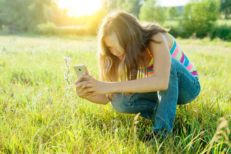 Retrato exterior de uma menina nova do adolescente que usa o smartphone para seu blogue, e páginas em redes sociais fotografia de stock royalty free Retrato exterior de uma menina nova do adolescente que usa o smartphone para seu blogue, e páginas em redes sociais fotografia de stock royalty free