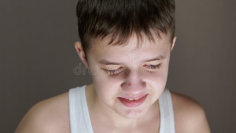 Retrato facial de un niño inocente sonriente con una mirada descendente. zoom. cerrar