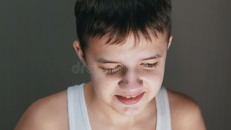 Retrato facial de un niño inocente sonriente con una mirada descendente. zoom. cerrar