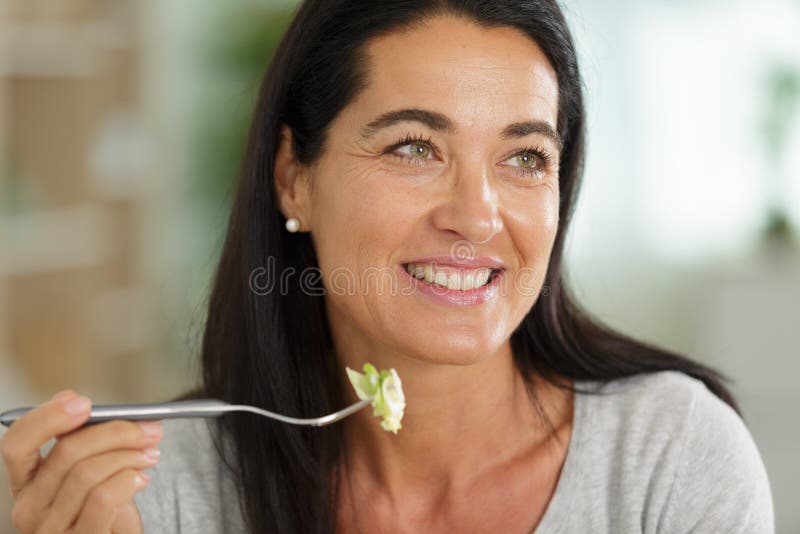 Retrato de uma mulher feliz a comer salada fotos de stock royalty free