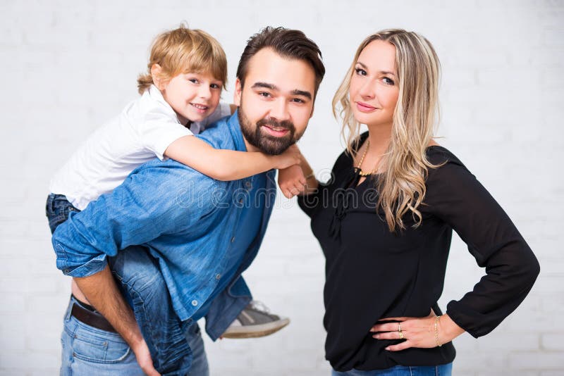 Retrato feliz da família - par com o filho pequeno bonito sobre o branco imagem de stock Retrato feliz da família - par com o filho pequeno bonito sobre o branco imagem de stock