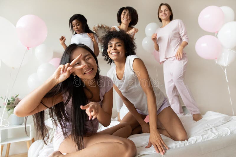 Retrato graciosas y hermosas chicas bailando en la cama en la fiesta de sonambulismo imagen de archivo libre de regalías