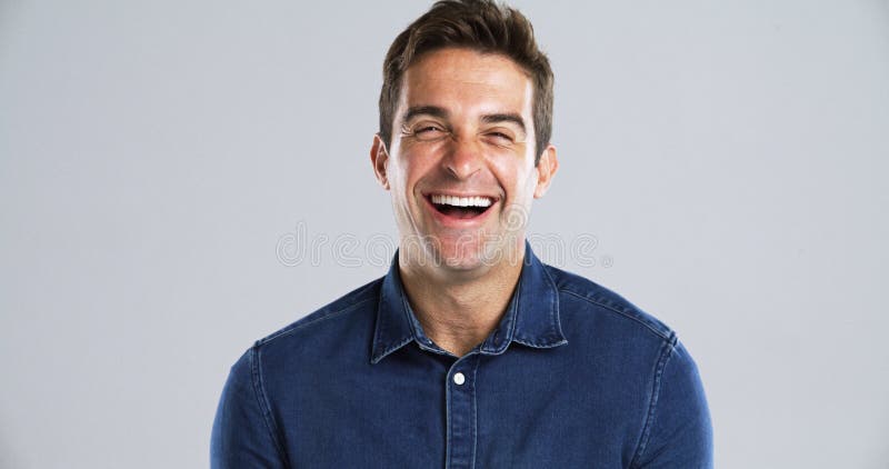 Retrato gracioso y hombre en sonrisa y humor de estudio con mentalidad positiva en el espacio de fondo gris. Cara a persona feliz fotos de archivo