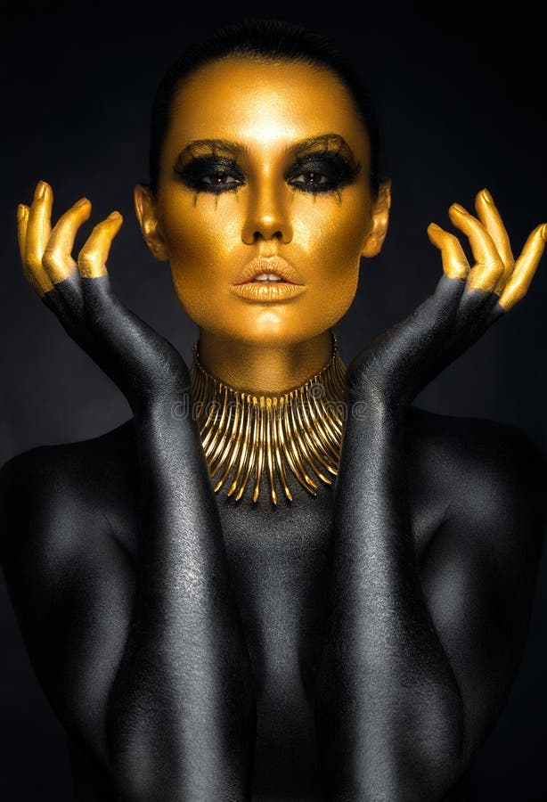 Retrato hermoso de la mujer en oro y colores negros