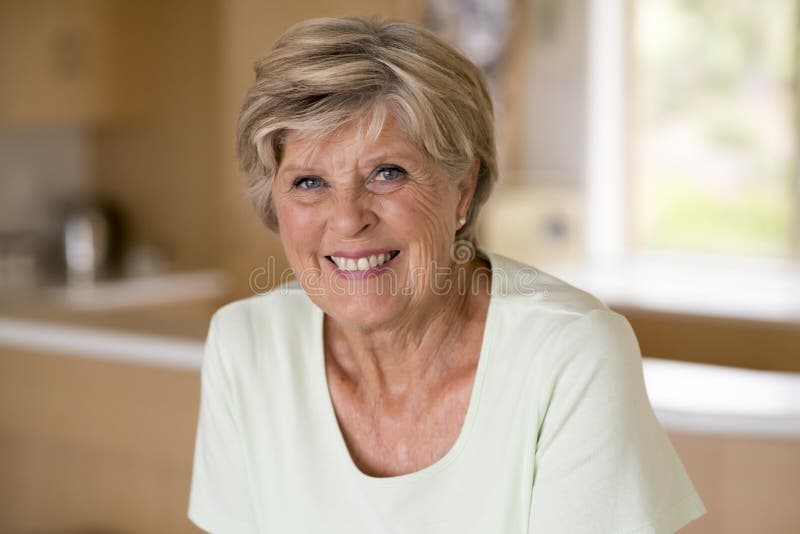 Retrato hermoso de la mujer madura mayor bonita y dulce en Edad Media alrededor 70 años que sonríe en casa ki feliz y amistoso fotografía de archivo Retrato hermoso de la mujer madura mayor bonita y dulce en Edad Media alrededor 70 años que sonríe en casa ki feliz y amistoso fotografía de archivo