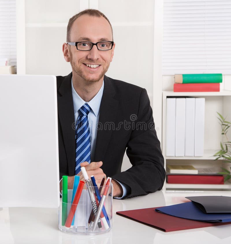 Retrato: Homem de negócios que senta-se em seu escritório com terno e laço foto de stock royalty free Retrato: Homem de negócios que senta-se em seu escritório com terno e laço foto de stock royalty free