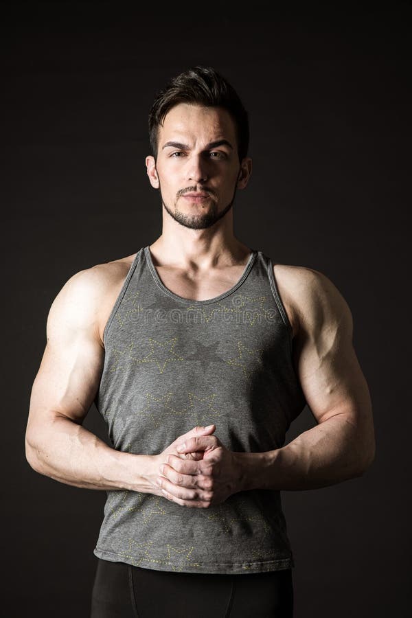 Retrato De Un Atleta Musculoso Atractivo Con Pesas Sobre Un Fondo Oscuro Foto De Archivo