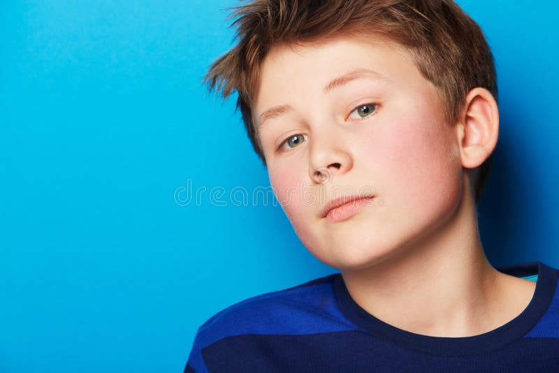 Retrato infantil y fondo azul con juventud de moda y ropa de moda en un estudio. niño y rostro foto de archivo