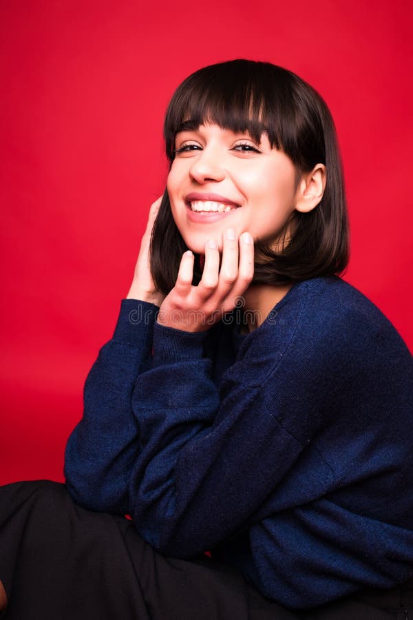 Retrato jovem e bonita mulher morena isolado em fundo vermelho foto de stock Retrato jovem e bonita mulher morena isolado em fundo vermelho foto de stock