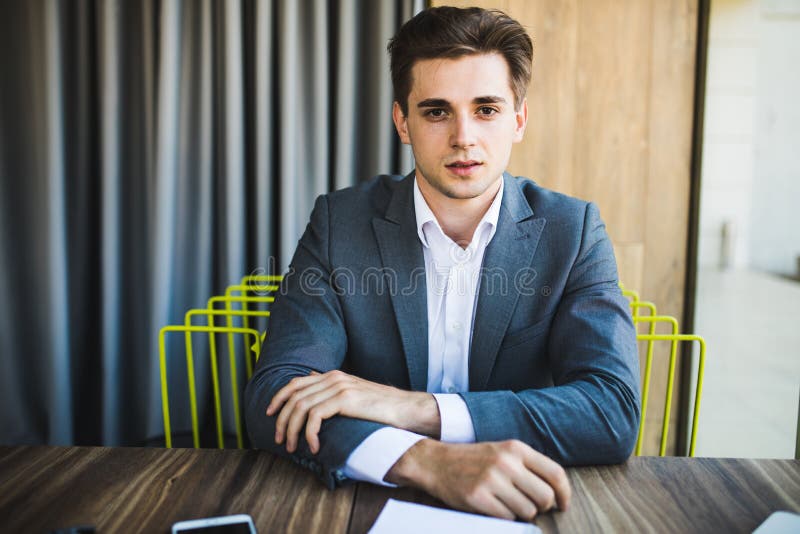 Retrato joven feliz del hombre de negocios en la oficina moderna brillante interior fotos de archivo libres de regalías Retrato joven feliz del hombre de negocios en la oficina moderna brillante interior fotos de archivo libres de regalías