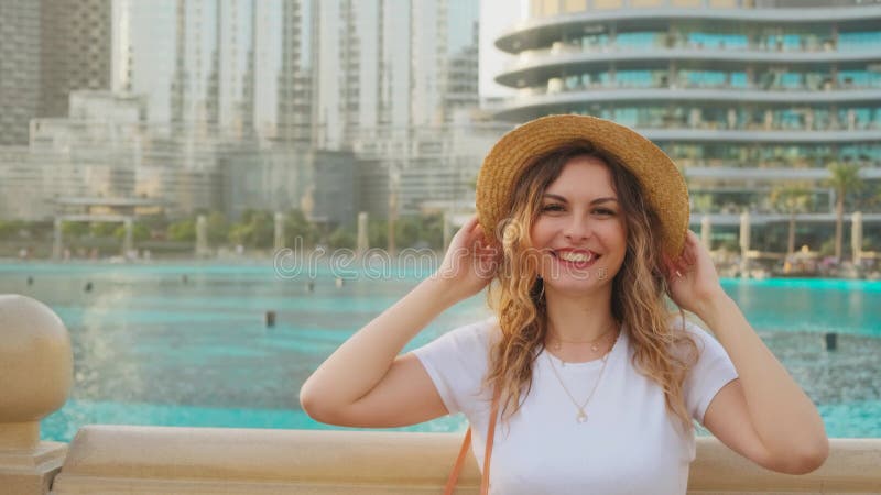 Retrato Joven turista sonriente cara feliz parada en el paseo marítimo de la ciudad de Dubai admira levantar las manos gritando co almacen de video