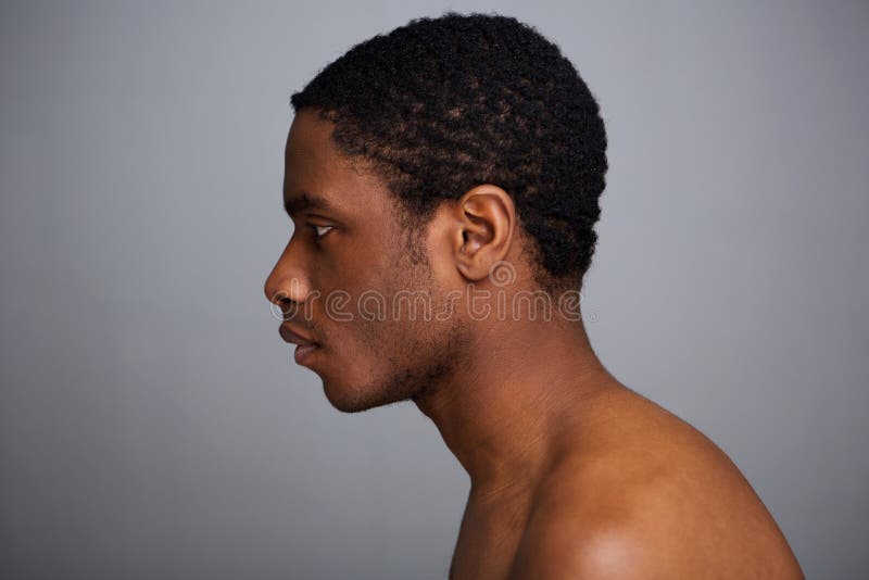Retrato lateral del hombre afroamericano descamisado contra fondo gris imagenes de archivo