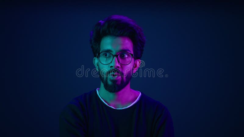 Retrato masculino de fondo neón sorprendido asombroso asombro de hombre indio hacker de informática trabajador de tecnología