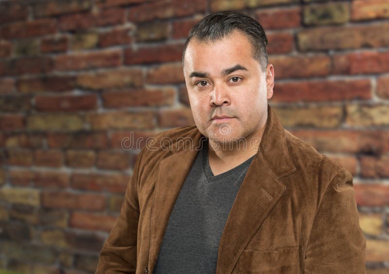 Retrato masculino hispánico joven hermoso del Headshot contra el ladrillo Wal imagenes de archivo