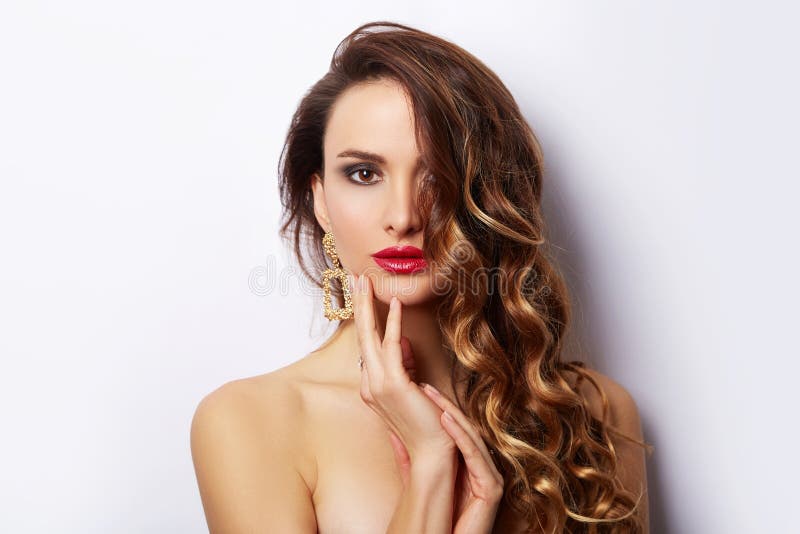Retrato moreno de la muchacha de la moda de la belleza con el pelo rizado Mujer atractiva del encanto que iguala los pendientes d fotos de archivo libres de regalías Retrato moreno de la muchacha de la moda de la belleza con el pelo rizado Mujer atractiva del encanto que iguala los pendientes d fotos de archivo libres de regalías