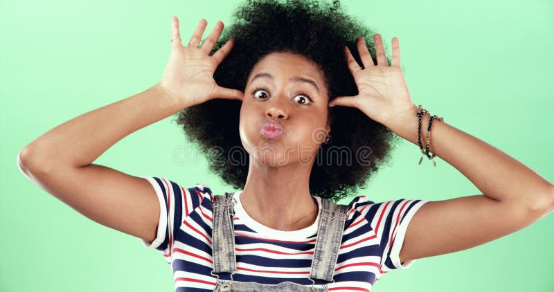 Retrato mujer divertida y negra en el estudio emoji y expresión facial sobre fondo verde. Persona africana estúpida y fotografía de archivo libre de regalías