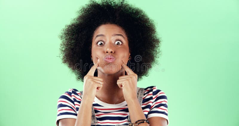 Retrato mujer divertida y negra en estudio loco y expresión facial en fondo verde. espacio para personas de África y imagen de archivo