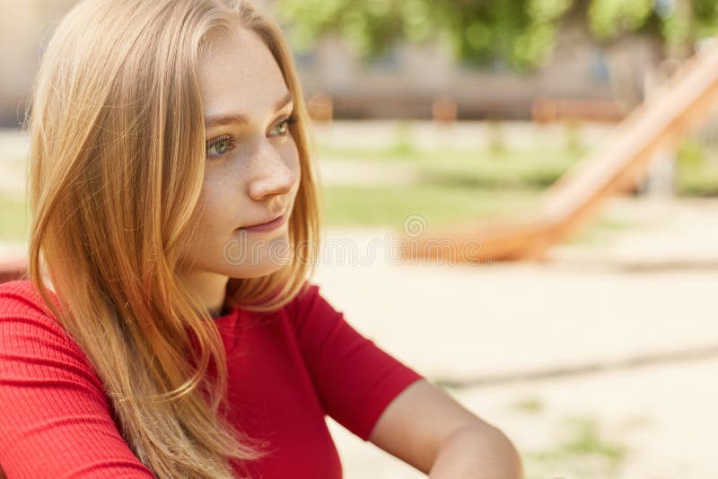 Retrato oblicuo de la muchacha bastante joven del estudiante con el pelo justo, los ojos encantadores y las pecas mirando pensati fotografía de archivo Retrato oblicuo de la muchacha bastante joven del estudiante con el pelo justo, los ojos encantadores y las pecas mirando pensati fotografía de archivo