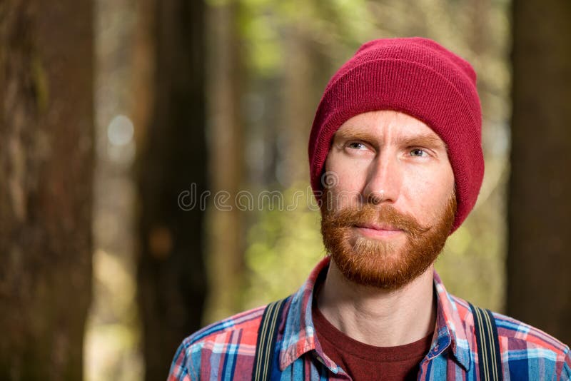 Retrato pensativo de um homem farpado em um chapéu vermelho fotos de stock royalty free Retrato pensativo de um homem farpado em um chapéu vermelho fotos de stock royalty free