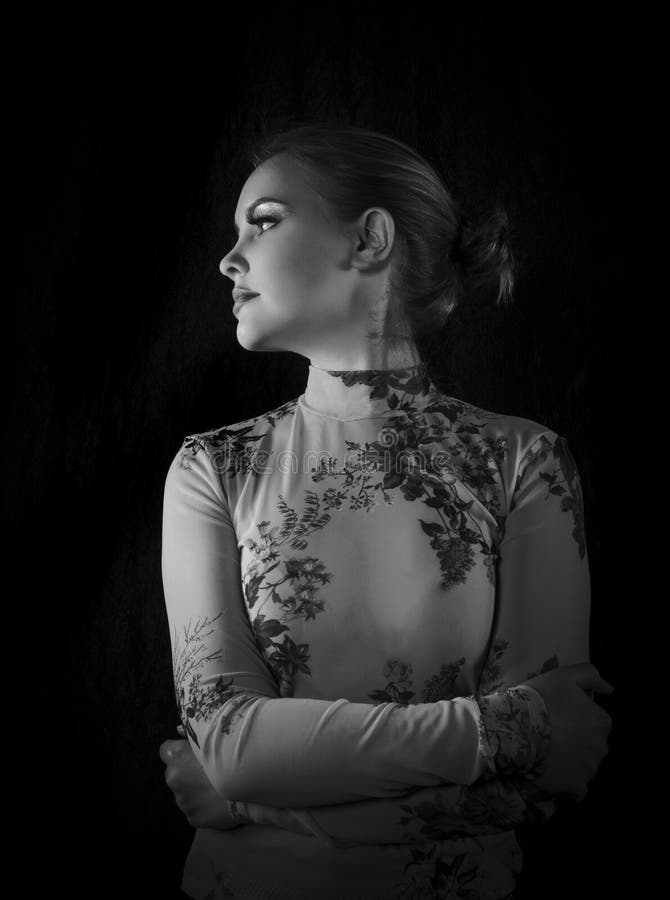Retrato preto e branco de uma linda loira usando uma camisa de malha floral padronizada e seu cabelo levantado fotos de stock Retrato preto e branco de uma linda loira usando uma camisa de malha floral padronizada e seu cabelo levantado fotos de stock