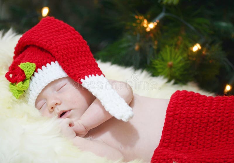 Retrato recién nacido del bebé que duerme en traje del punto de la Navidad en la manta blanca de la piel fotografía de archivo Retrato recién nacido del bebé que duerme en traje del punto de la Navidad en la manta blanca de la piel fotografía de archivo