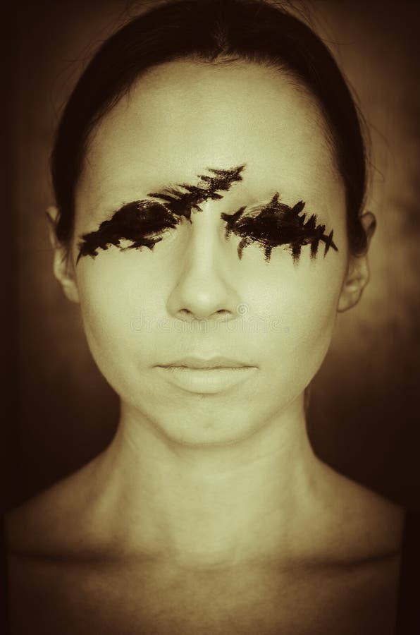 Retrato temeroso de una mujer joven sin los ojos en retro oscuro del fondo entonado. Retrato temeroso del primer de una mujer joven sin los ojos en retro azul marino del fondo entonado