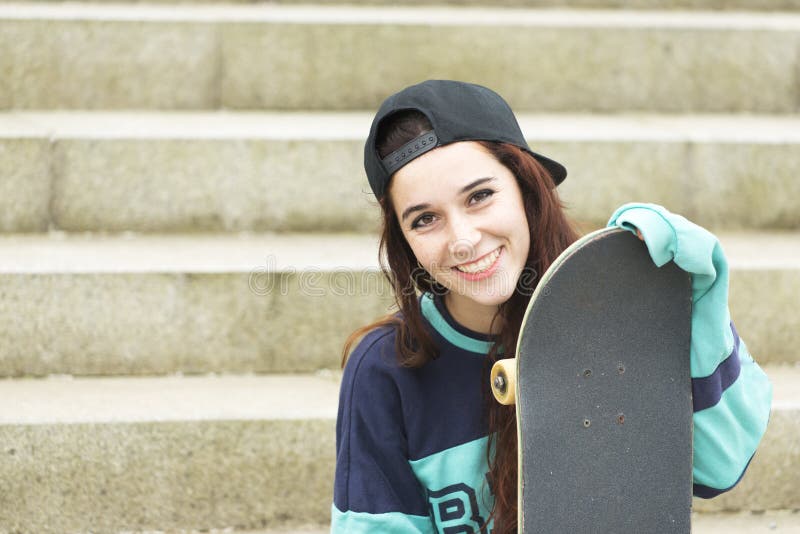 Retrato urbano da jovem mulher alegre com skate imagem de stock Retrato urbano da jovem mulher alegre com skate imagem de stock
