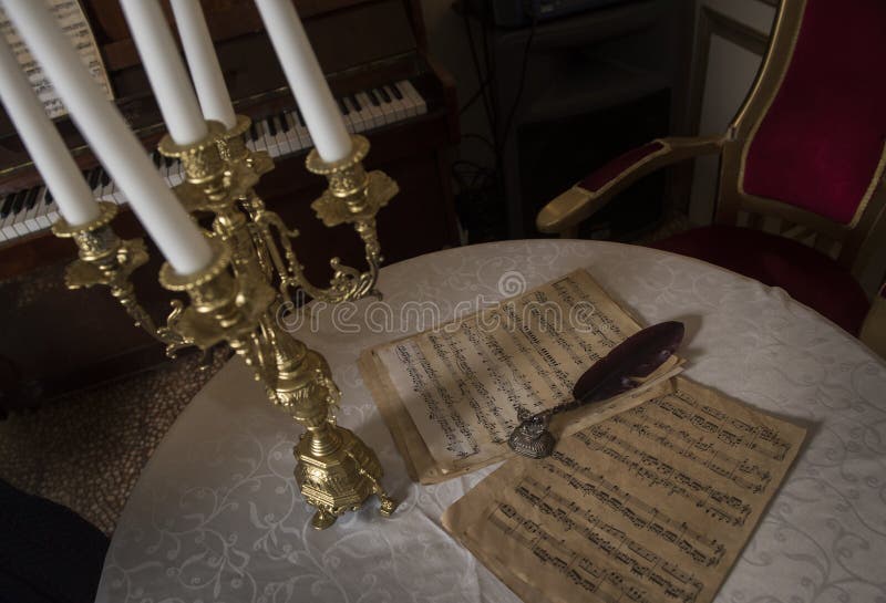 Retro bladmuziek en de veer van die tijd en een mooie gouden kandelaar royalty-vrije stock afbeeldingen Retro bladmuziek en de veer van die tijd en een mooie gouden kandelaar royalty-vrije stock afbeeldingen