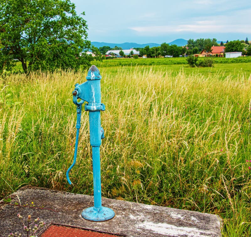 Retro čerpadlo do vrtu za slnečného dňa, stará ručná vodná pumpa (pákové čerpadlo).