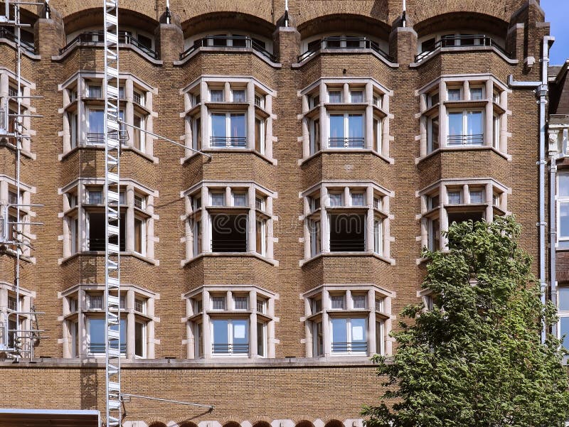 Retro brick wall building facade under renovation with open windows