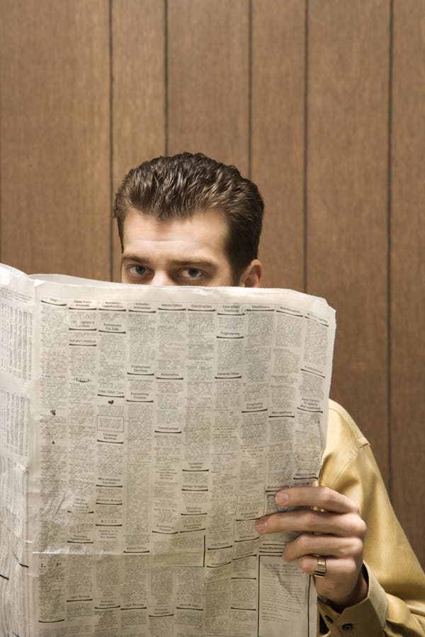 Retro businessman peeking over newspaper.