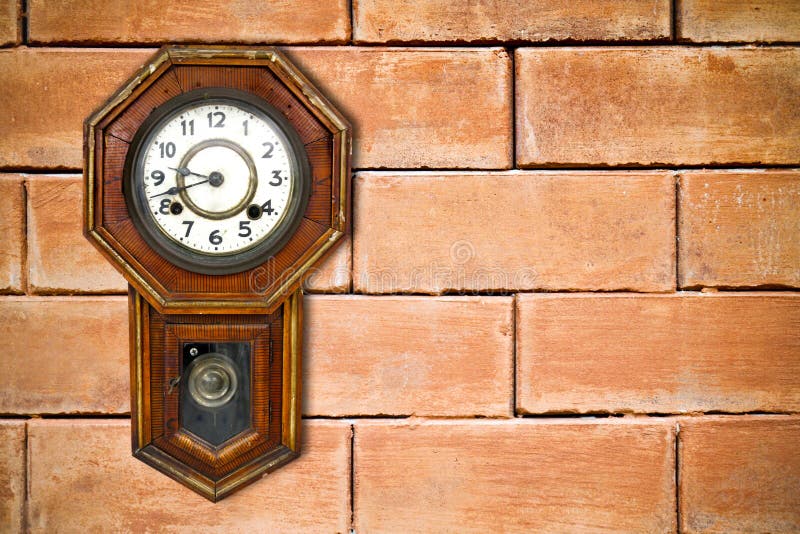 Retro clock hanging on brick wall