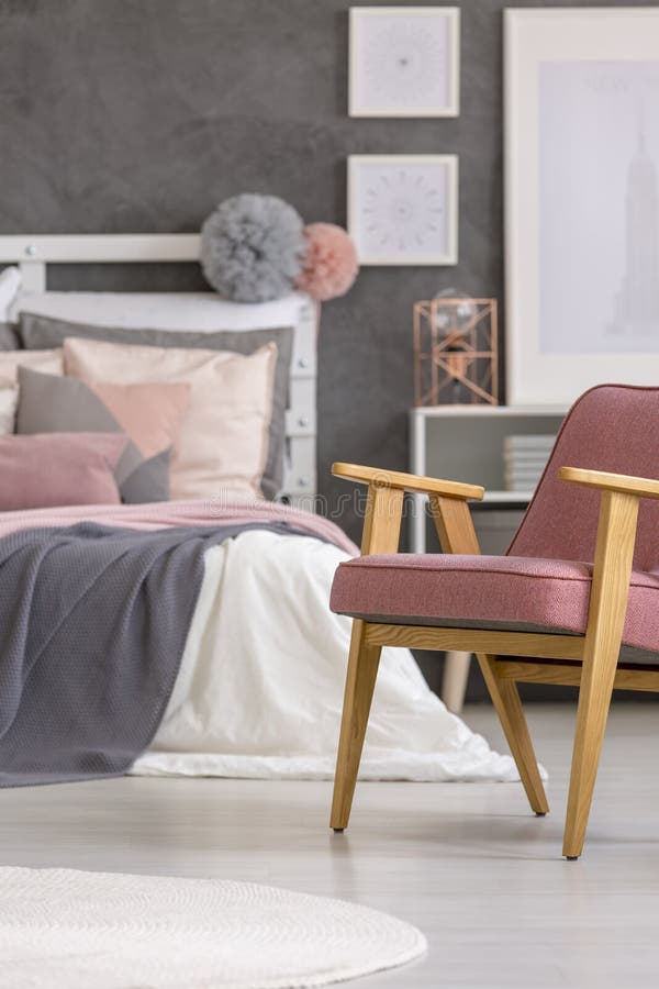 Retro armchair standing on white, wooden floors in a gray and pastel girly bedroom interior. Retro armchair standing on white, wooden floors in a gray and pastel girly bedroom interior