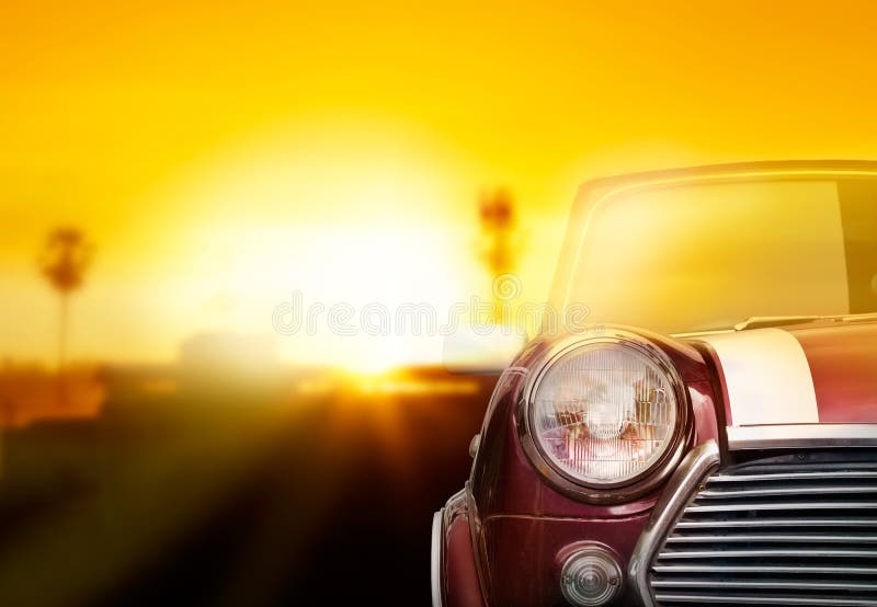 Retro luce della testa dell'automobile sulla via nei precedenti di tramonto immagine stock Retro luce della testa dell'automobile sulla via nei precedenti di tramonto immagine stock