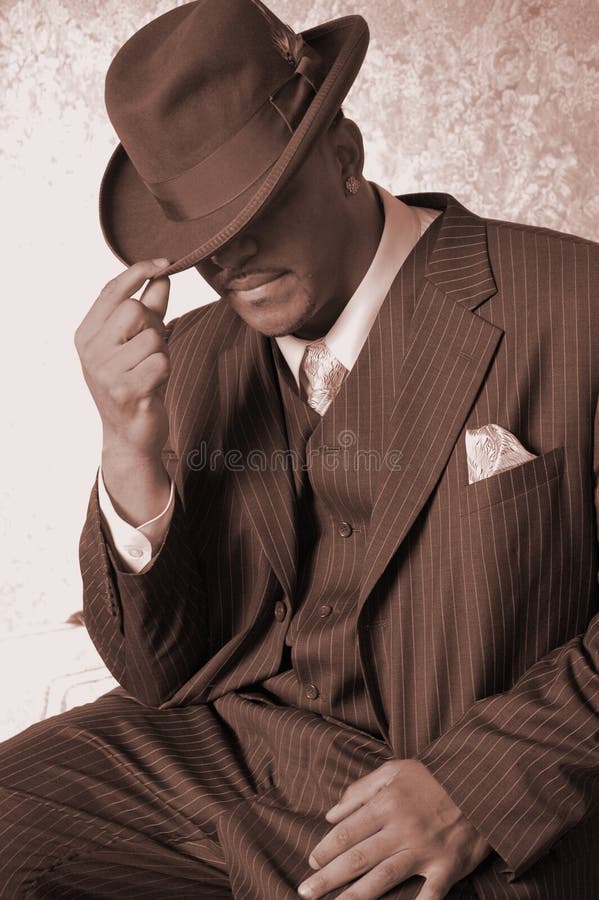 Male in a pin stripped suit hand on the brim. Male in a pin stripped suit hand on the brim