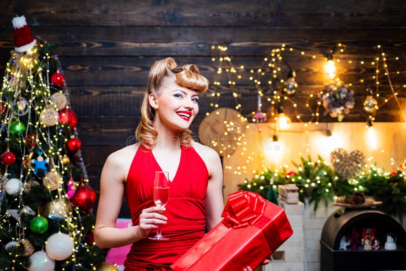 Retro pin-up woman posing on vintage wooden Christmas background. Merry Christmas and happy new year. Young woman in stock photography Retro pin-up woman posing on vintage wooden Christmas background. Merry Christmas and happy new year. Young woman in stock photography