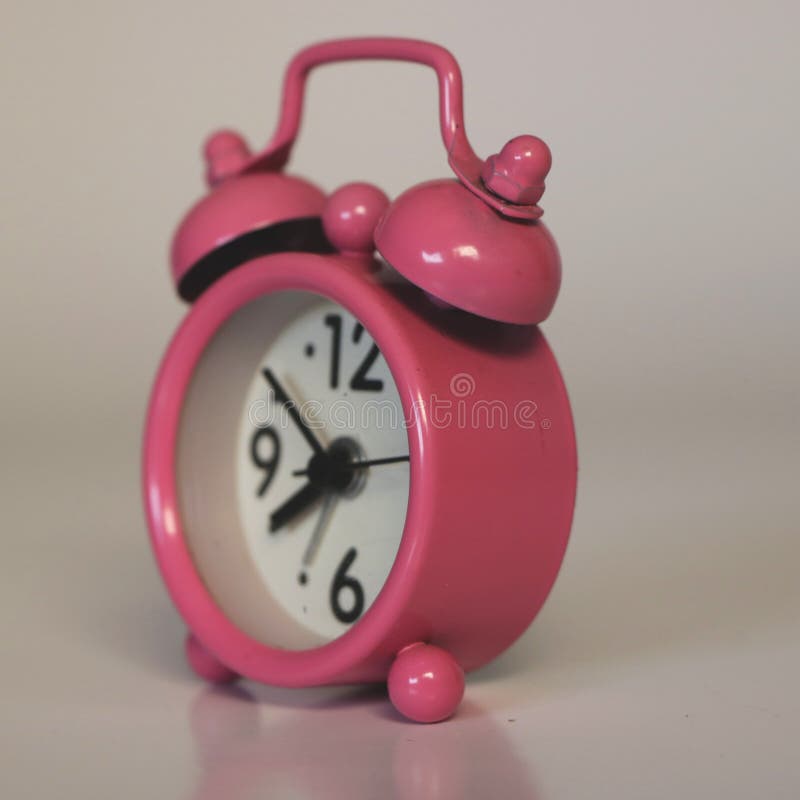 Retro Pink Miniature Alarm Clock on White Background Side Stock Image