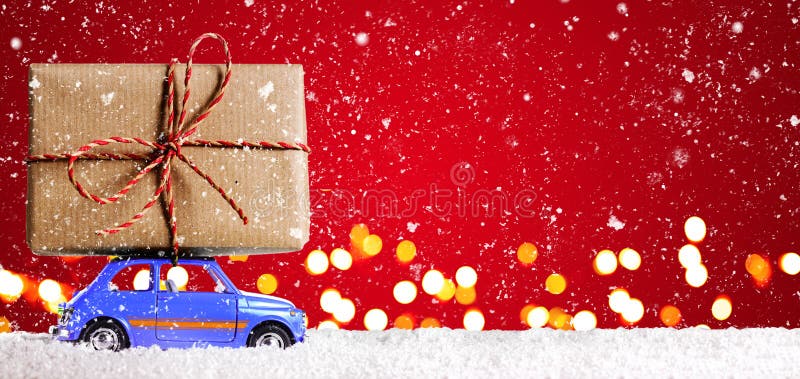 Blue retro toy car delivering Christmas or New Year gifts on festive red background. Blue retro toy car delivering Christmas or New Year gifts on festive red background