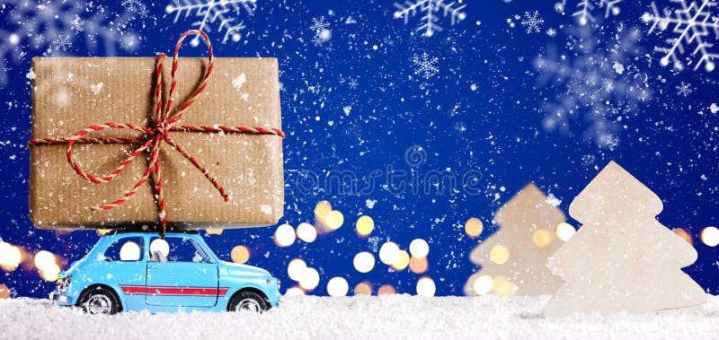 Retro toy car delivering Christmas or New Year gifts on festive blue background. Retro toy car delivering Christmas or New Year gifts on festive blue background