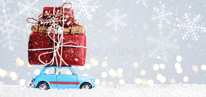 Blue retro toy car delivering Christmas or New Year gifts on festive gray background. Blue retro toy car delivering Christmas or New Year gifts on festive gray background